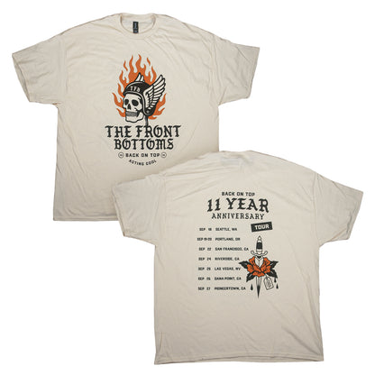 Off-white Gildan Heavy Cotton T-shirt shown from front and back, featuring a flaming skull graphic on the front and a list of tour dates for The Front Bottoms 11 Year Anniversary on the back.