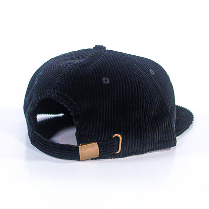 A black corduroy baseball cap from The Front Bottoms' Class Chord Hats collection, shown from the back, featuring an adjustable strap with a gold buckle—perfect for fans of quality embroidered hats.